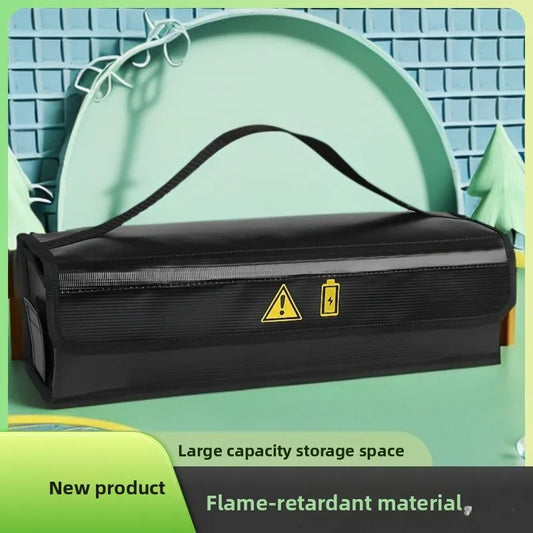 A black rectangular storage bag with a top handle, shown on a stylized mint-green background. The bag has yellow warning and battery symbols printed on the front, along with text overlays reading 'Large capacity storage space', 'New product', and 'Flame-retardant material'.