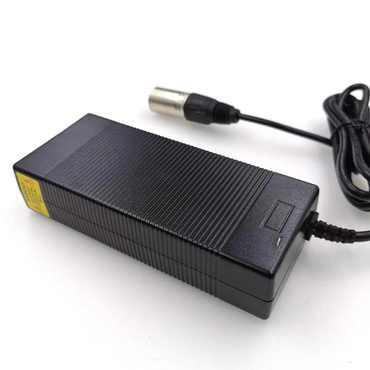 A black rectangular power adapter with a ribbed top surface, a yellow warning label on one end, and a black cable ending in a silver metal plug, shown on a white background.