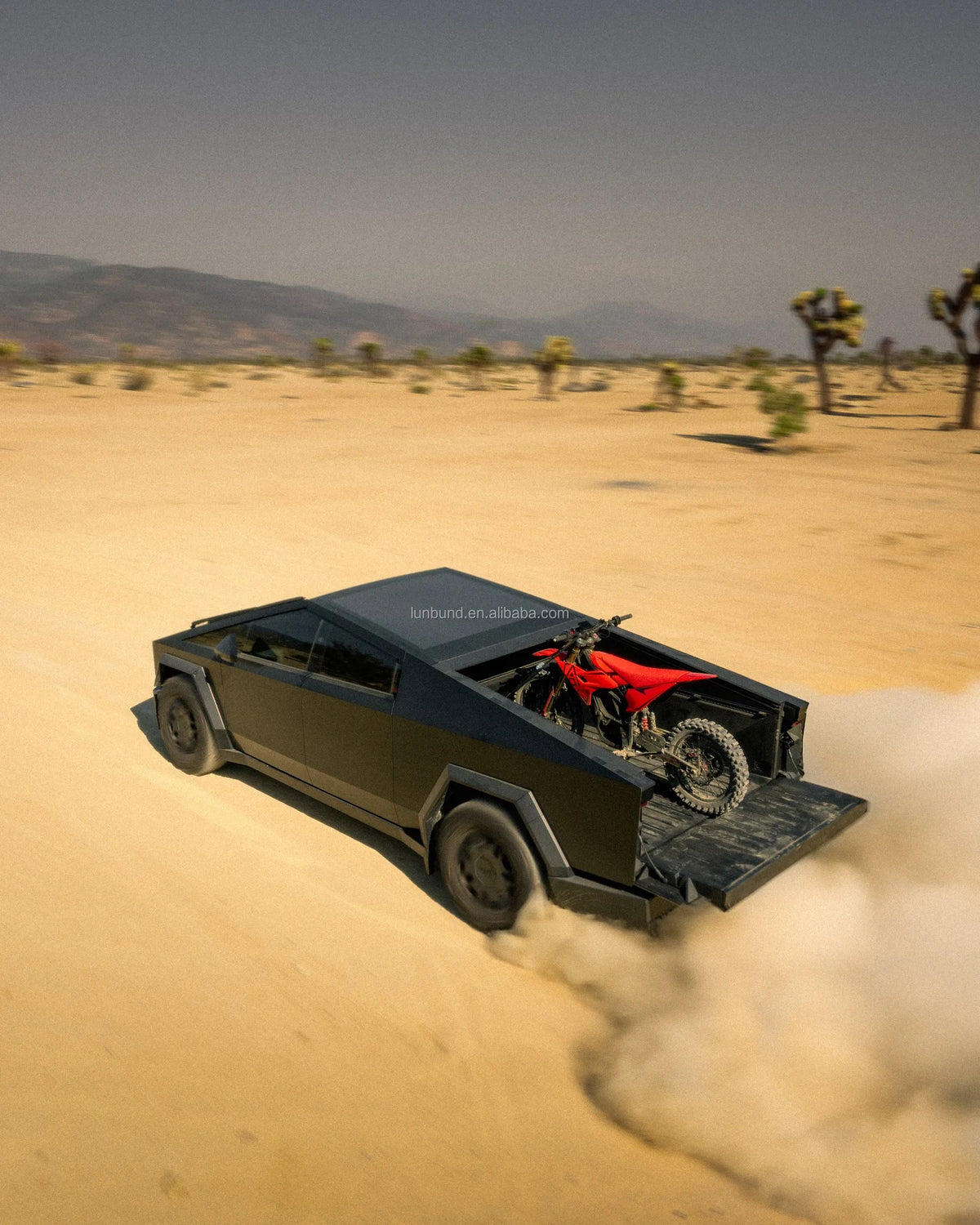 Black off-road vehicle with a red motorcycle in a desert setting