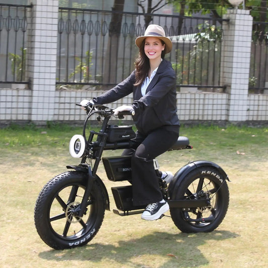 Woman riding a black electric bike outdoors on a sunny day.