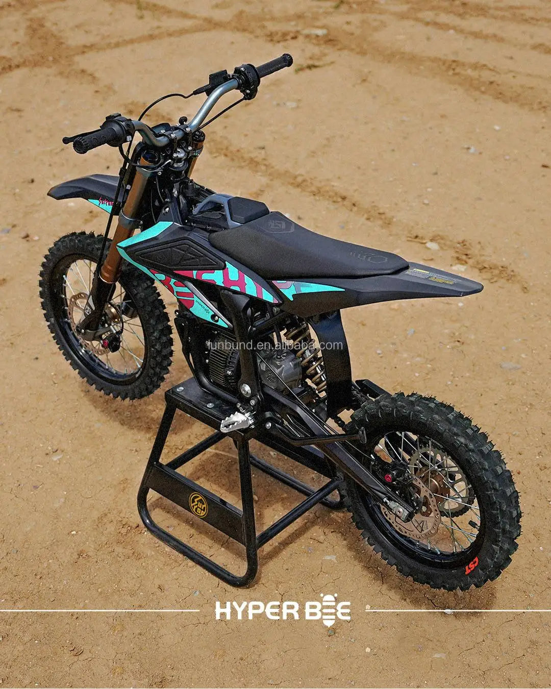 Small dirt bike with colorful design on a sandy surface, featuring the brand 'Hyper BEE'.