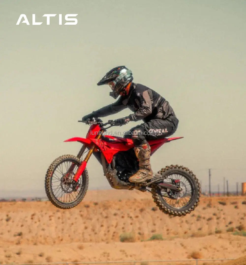 Person riding a red dirt bike in an open desert area with 'ALTIS' branding.