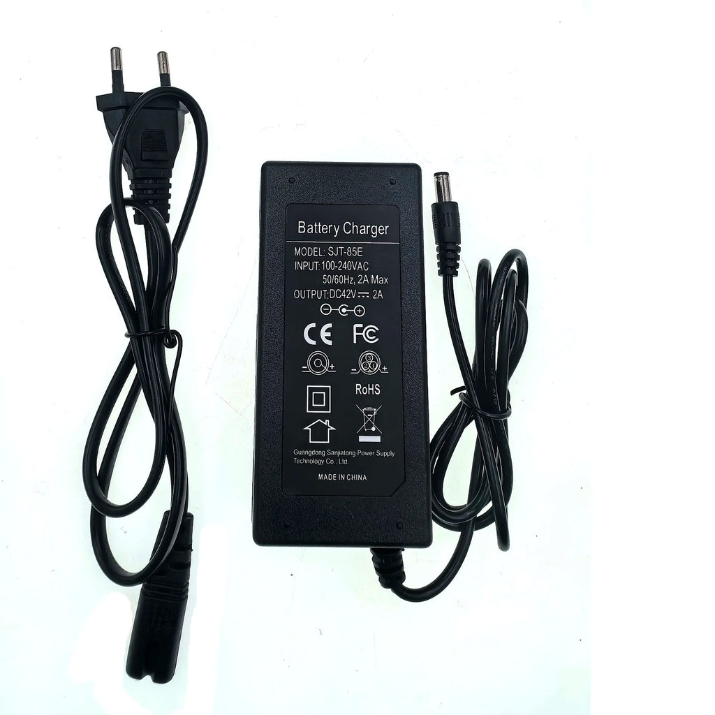 A black DC battery charger adapter with a two-pin plug on one end and a barrel connector on the other, shown on a plain white background. The top of the unit has white printed specifications and certification logos.