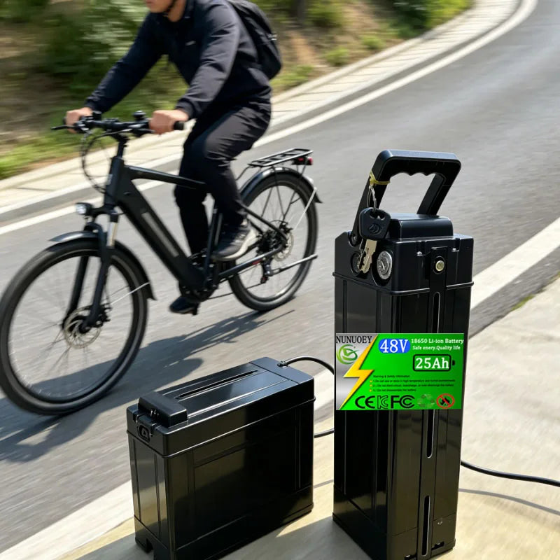 A black portable electric bicycle battery charger and battery pack shown outdoors on a paved path, with a person riding a black bicycle blurred in the background. The battery pack has a green and white specification label reading 48V, 25Ah, and NINJOGU.