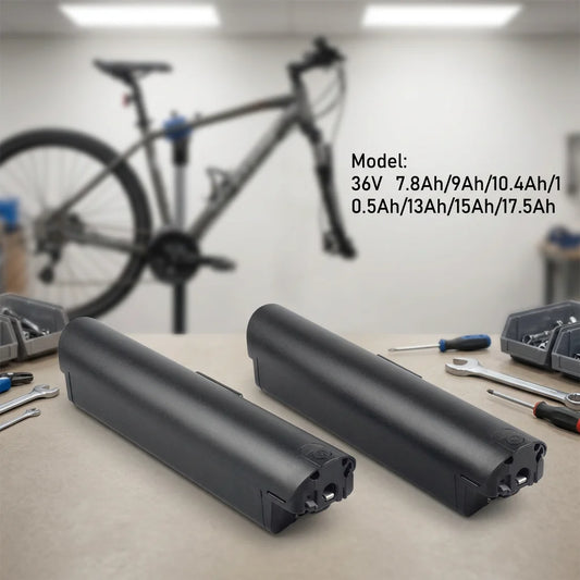 Two black bicycle replacement batteries displayed on a workbench with tools and a blurred bicycle in the background. Text on the image lists the battery model and capacities.