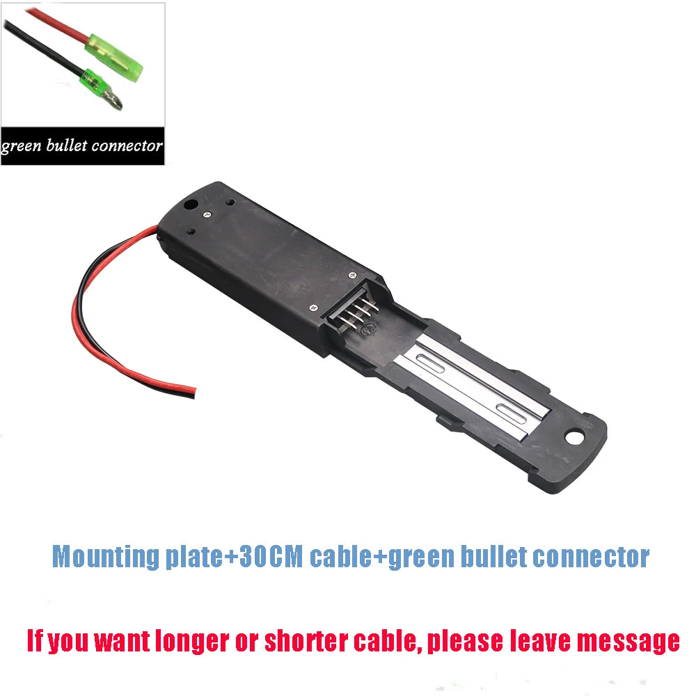 A black plastic battery compartment cover with attached red and black wires and a green bullet connector, shown on a white background with text describing the components and a small inset of the connector.