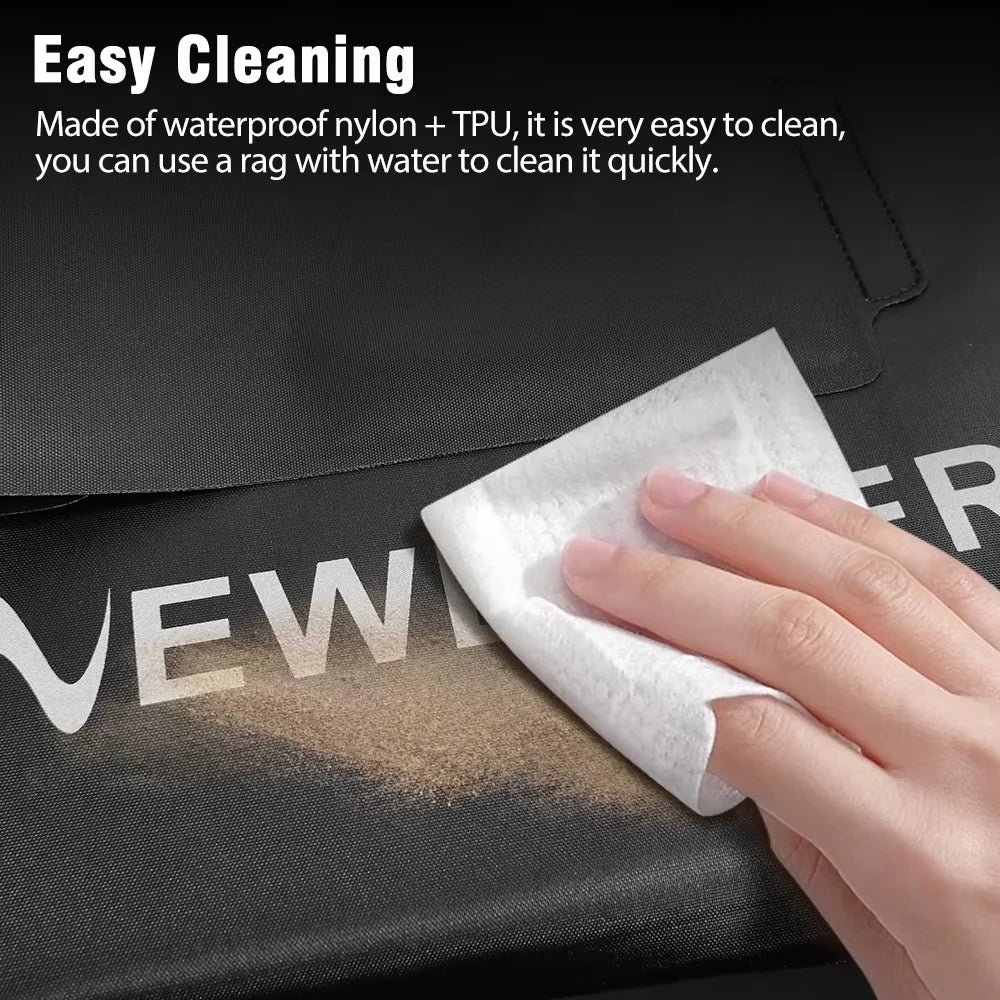 A close-up of a hand wiping a black waterproof nylon and TPU surface with a white cloth, with text at the top reading 'Easy Cleaning' and a smudge of dirt shown to demonstrate cleaning.