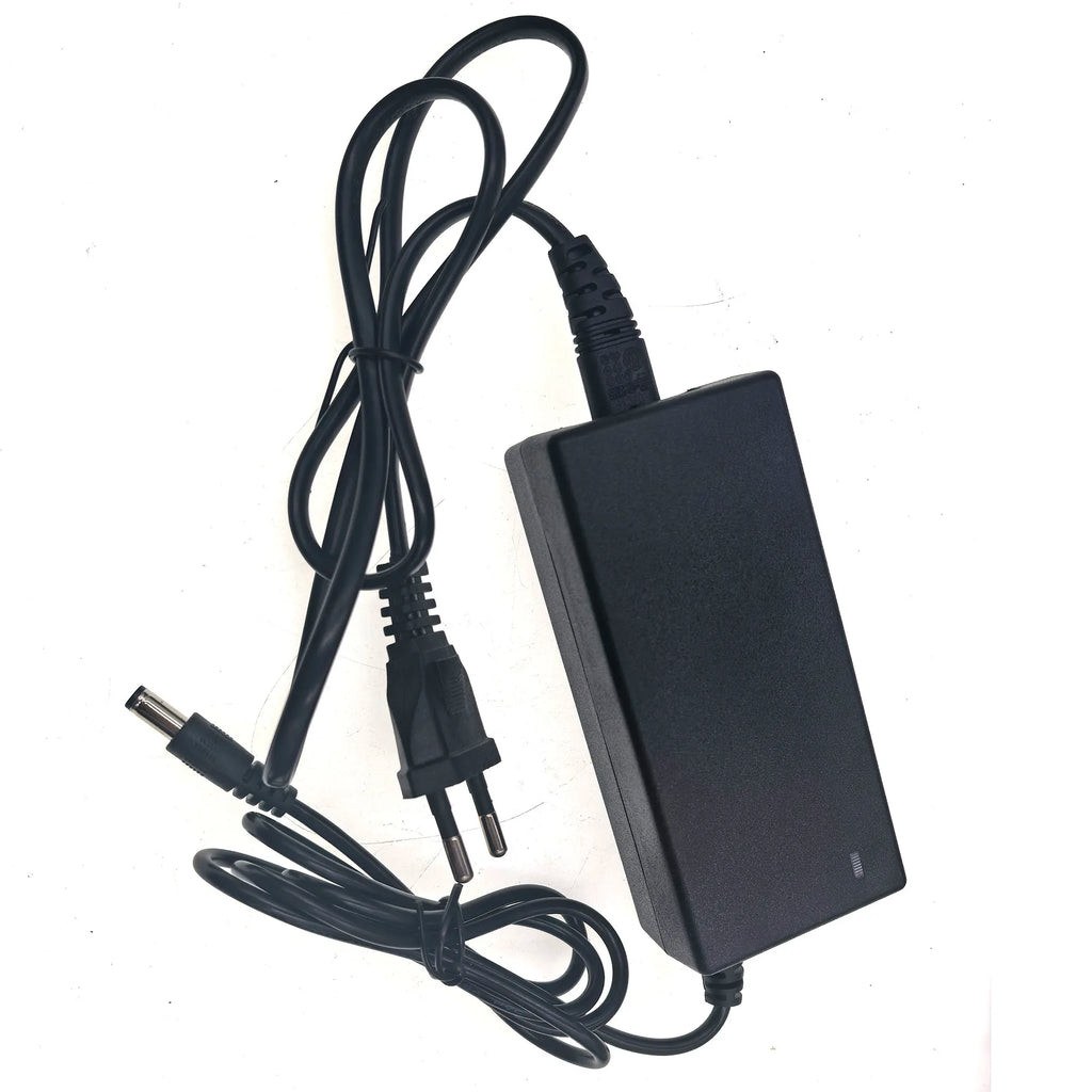 A black AC adapter power supply with a coiled black cable, showing the DC barrel connector on one end and a two-pin plug on the other, photographed on a plain white background.