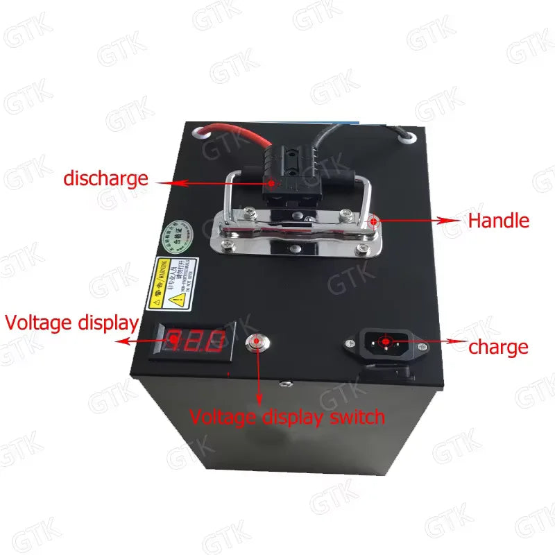 Black rectangular battery with a digital voltage display, red and black cables at the top, and red text labels pointing to discharge, handle, charge, and voltage display switch on a white background.