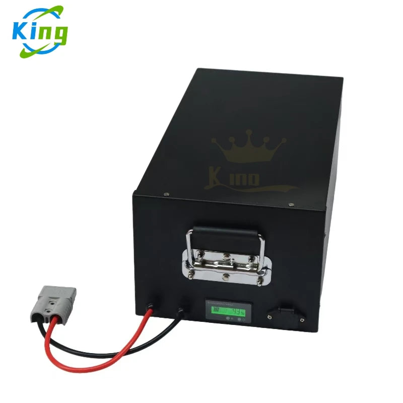 A black rectangular battery box with a metal handle, a small green display, and attached red and black cables, shown on a white background with a King logo in the top-left corner.