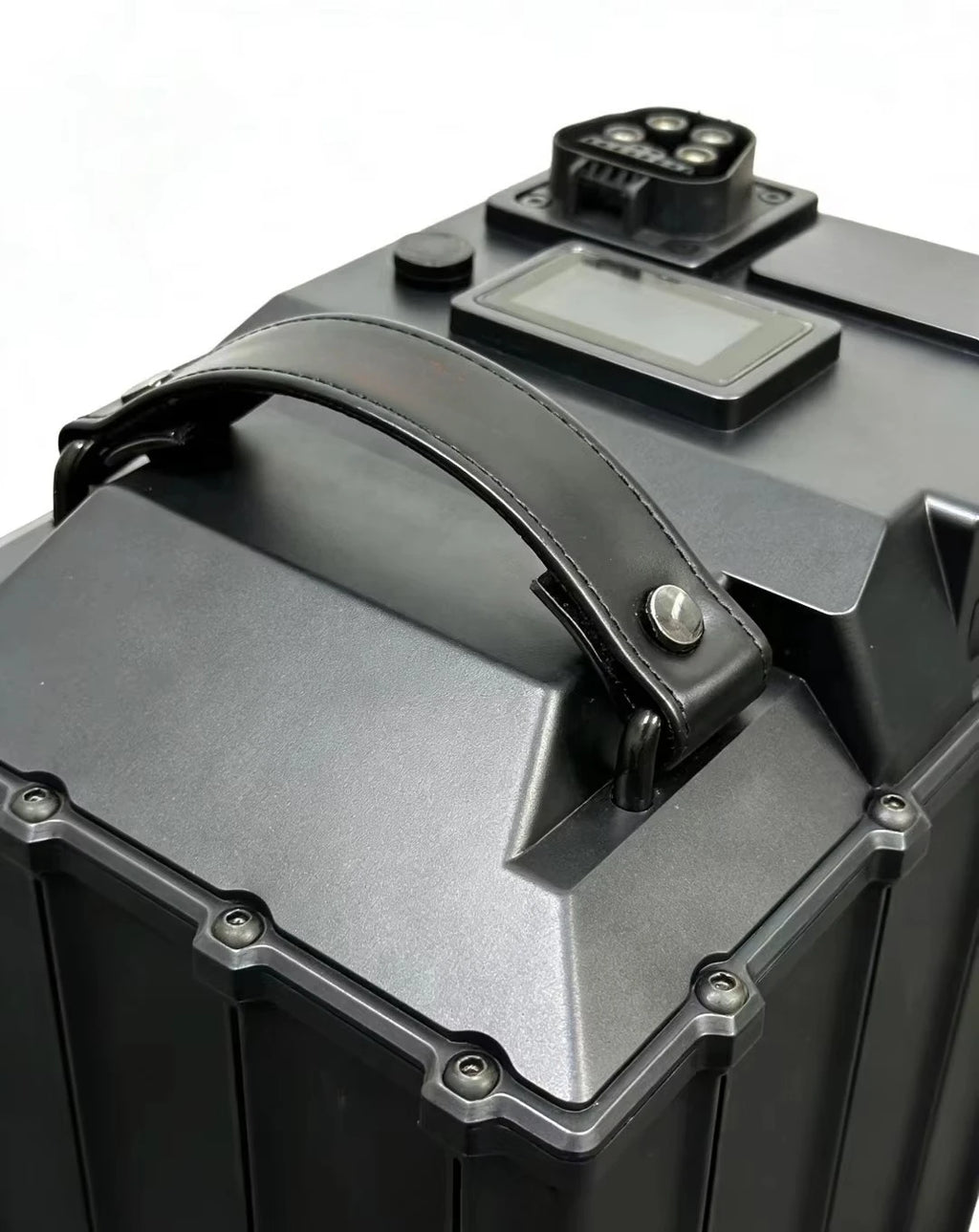 Close-up of a rugged black and dark gray hard case with a top handle, a small display screen, and a connector port on a white background.