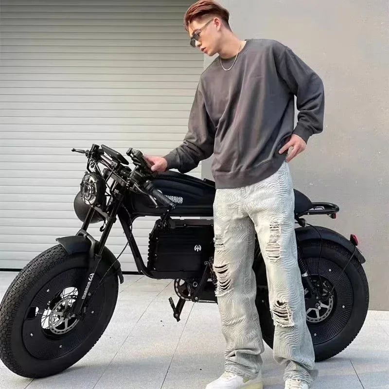 Person standing next to a black motorcycle in an urban setting