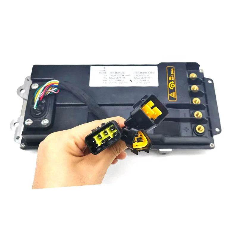 A black electronic control module with yellow connector details, held by a hand against a white background.